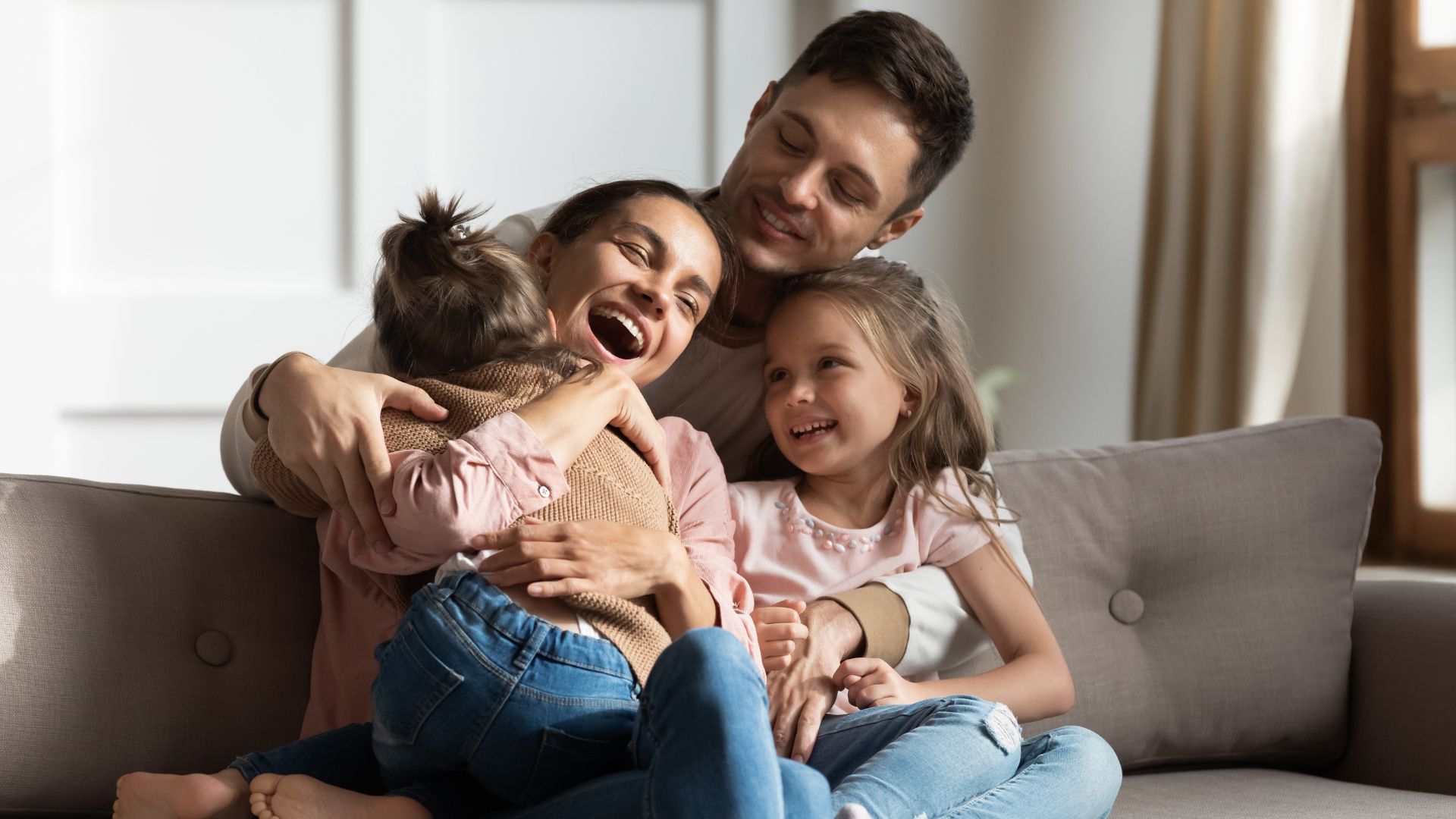 Family hugging on couch